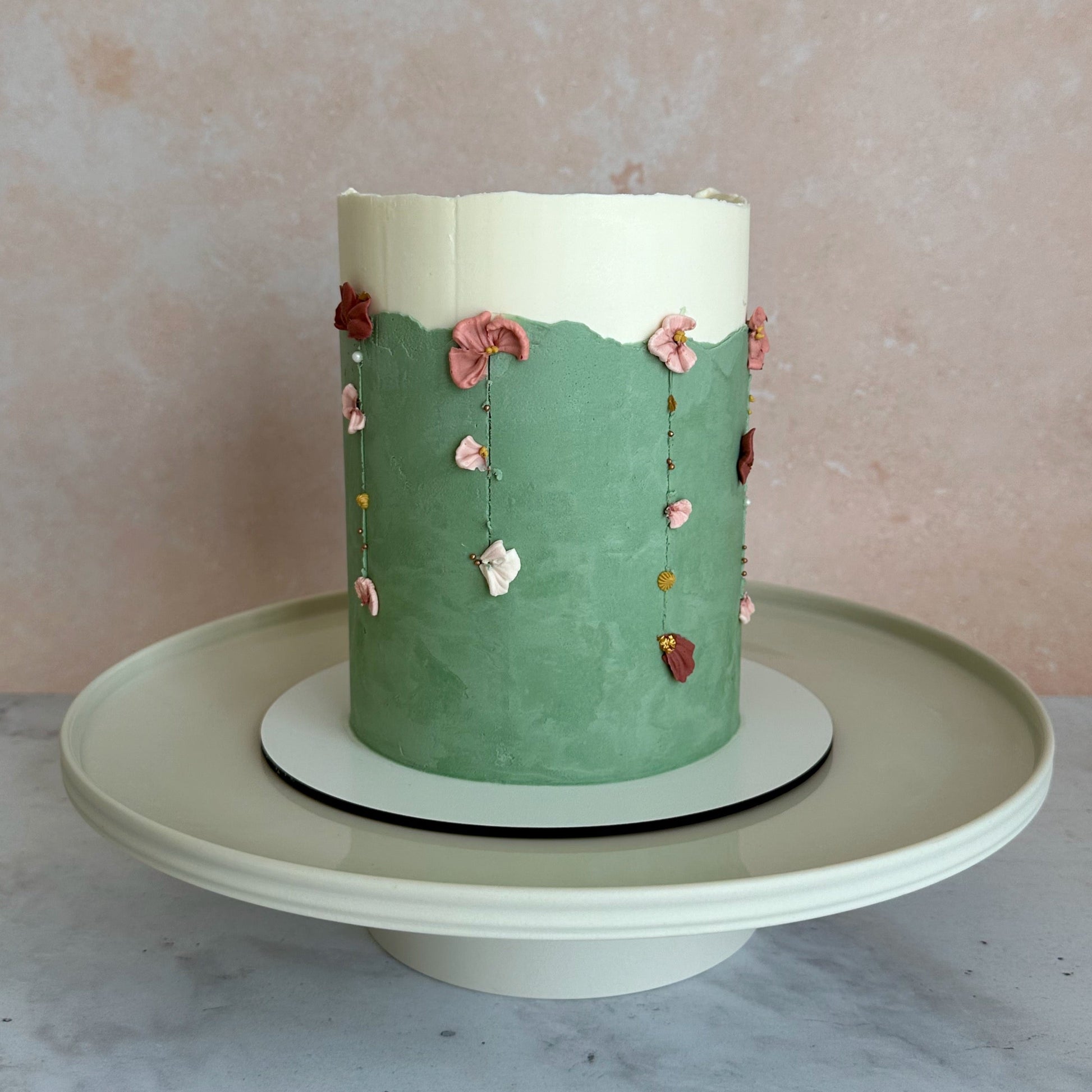 A birthday cake with strings of floral drips