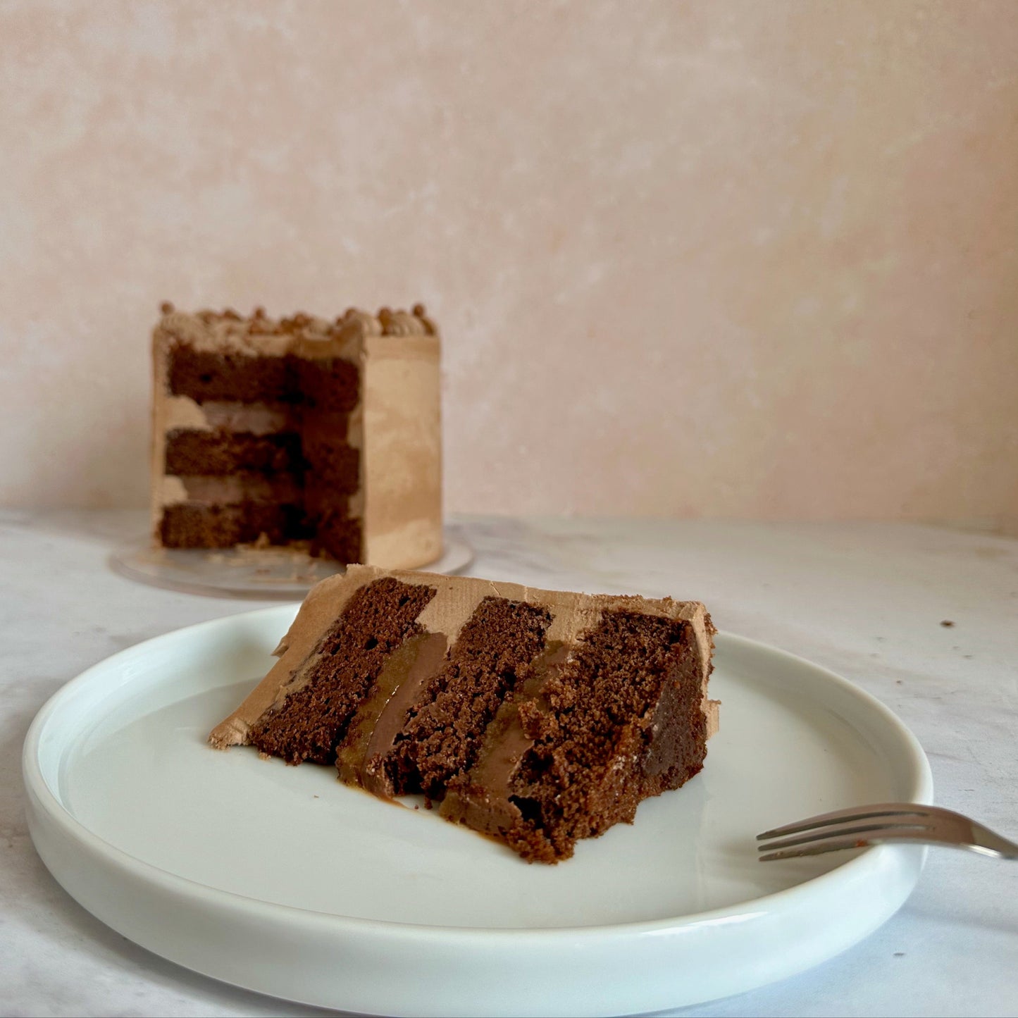 Chocolate cake slice filled with milk chocolate ganache and salted caramel.